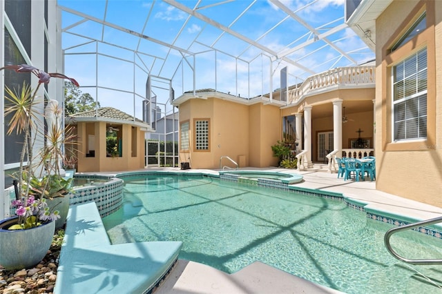 view of pool with a lanai, a patio, a pool with connected hot tub, and a ceiling fan