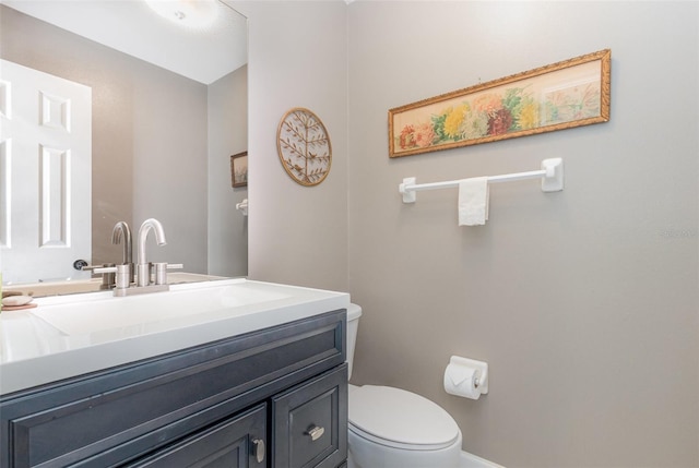 half bath featuring toilet, baseboards, and vanity