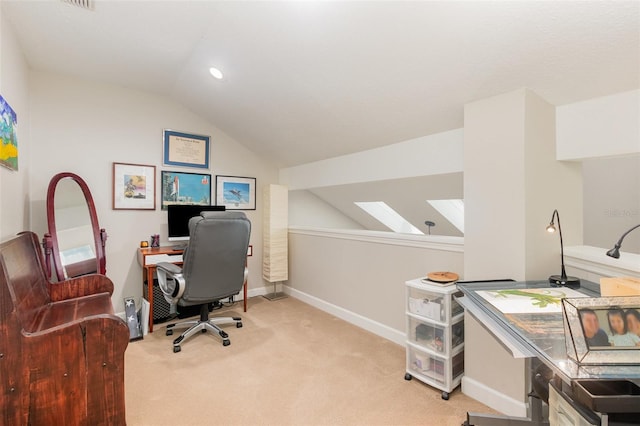 carpeted office space featuring baseboards and vaulted ceiling with skylight
