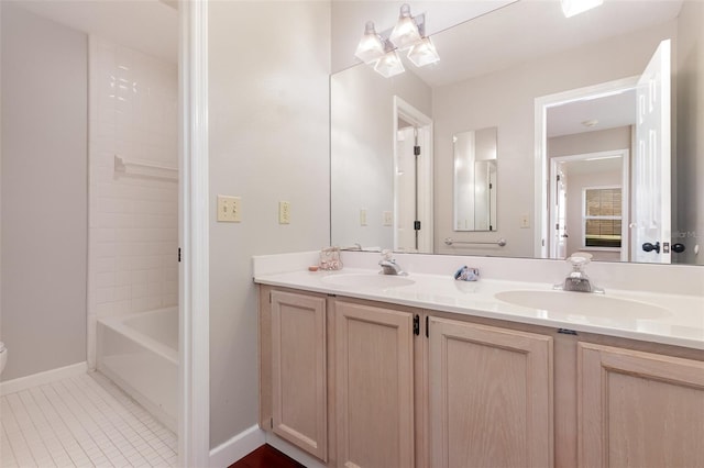 full bathroom with double vanity, a sink, baseboards, and tile patterned floors