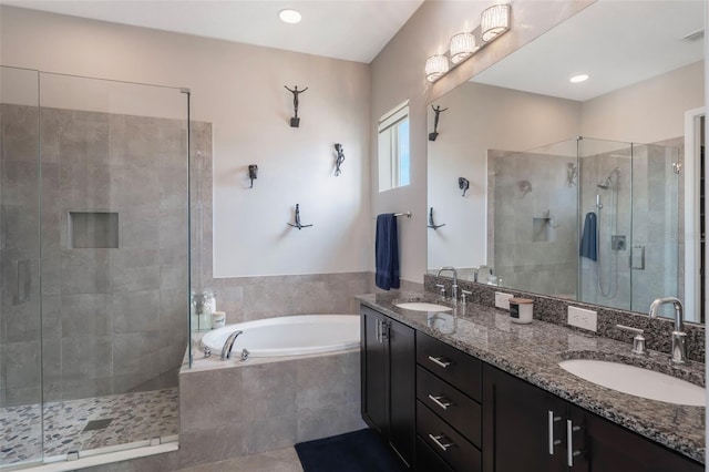 full bathroom featuring double vanity, a sink, a bath, and a shower stall