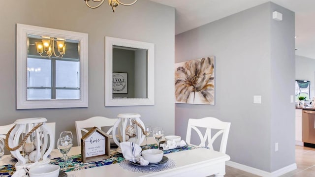dining room featuring a chandelier and baseboards