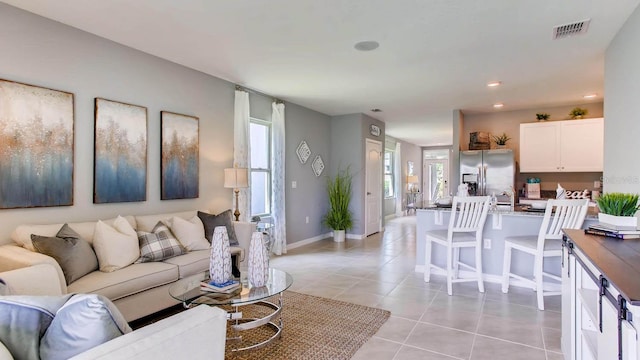 living area with baseboards, visible vents, light tile patterned floors, and recessed lighting