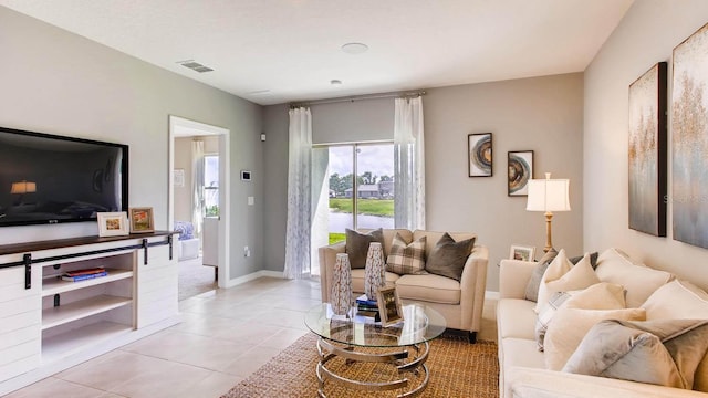 living room featuring light tile patterned floors, visible vents, and baseboards