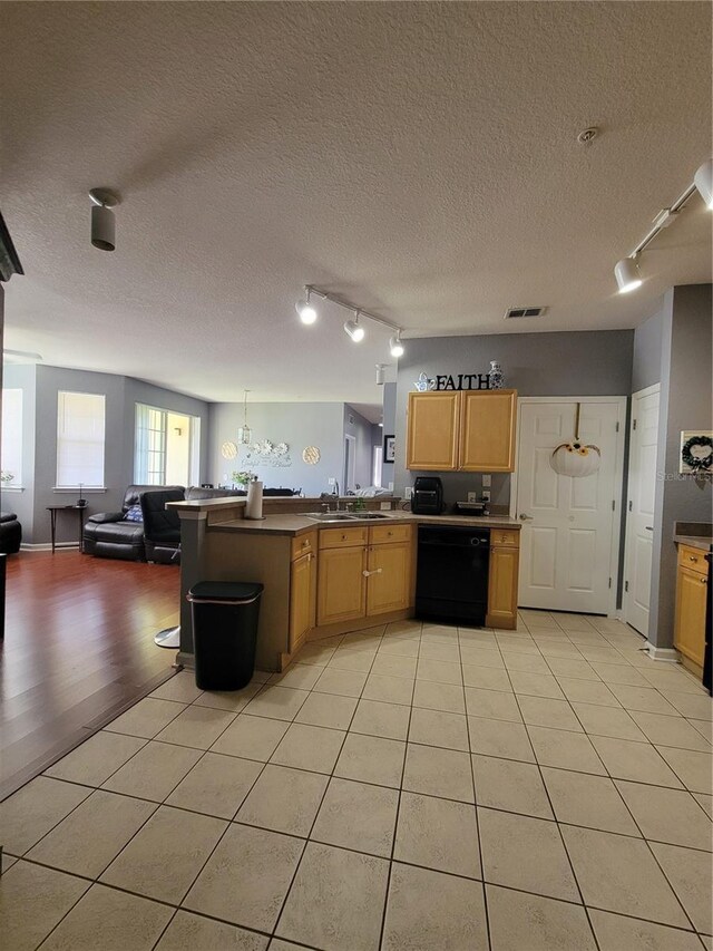 kitchen with visible vents, rail lighting, dishwasher, and open floor plan