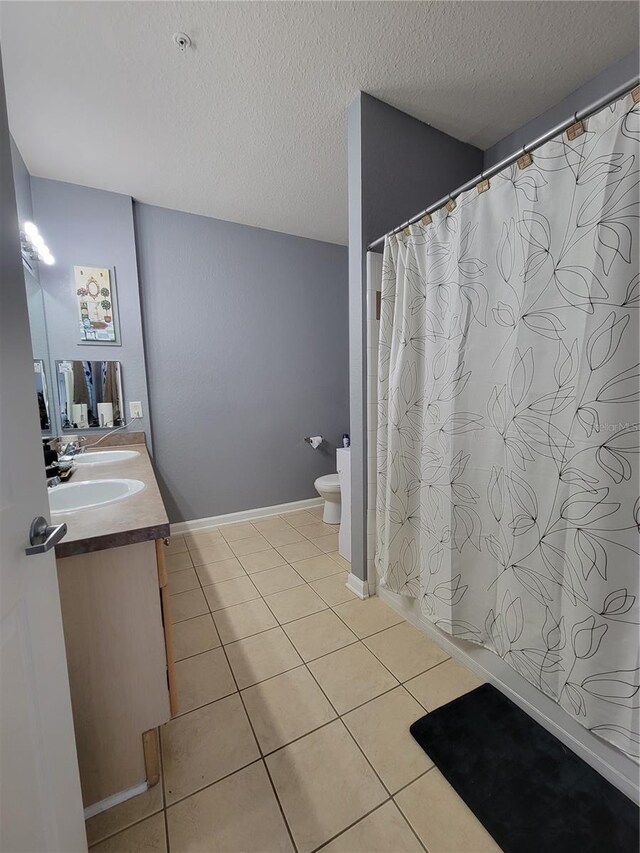 full bath with vanity, toilet, tile patterned floors, a textured ceiling, and curtained shower