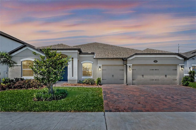 3332 Lone Cypress Pt, Oviedo, FL 32765 - view of front of house with decorative driveway, an attached garage, stucco siding, a lawn, and a shingled roof