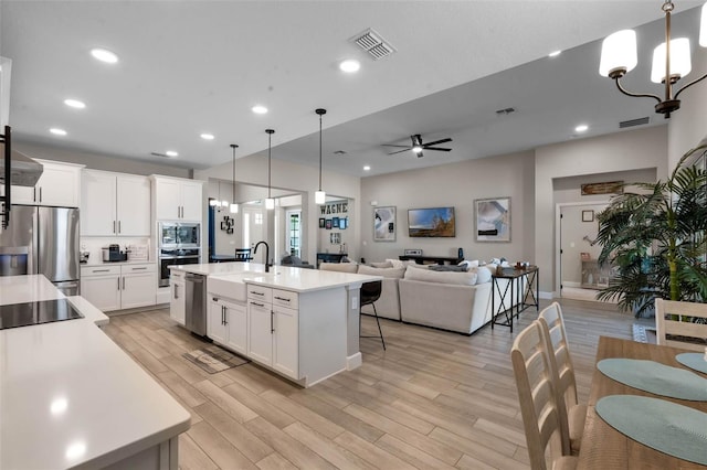 3332 Lone Cypress Pt, Oviedo, FL 32765 - kitchen featuring appliances with stainless steel finishes, a sink, light wood-type flooring, light countertops, and recessed lighting