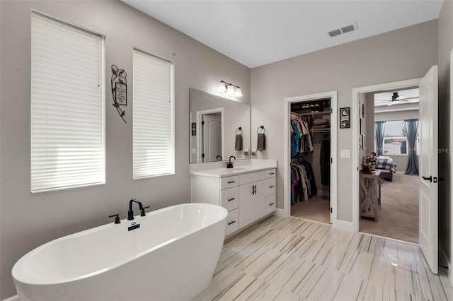 3332 Lone Cypress Pt, Oviedo, FL 32765 - ensuite bathroom featuring a freestanding tub, vanity, a walk in closet, a ceiling fan, and baseboards