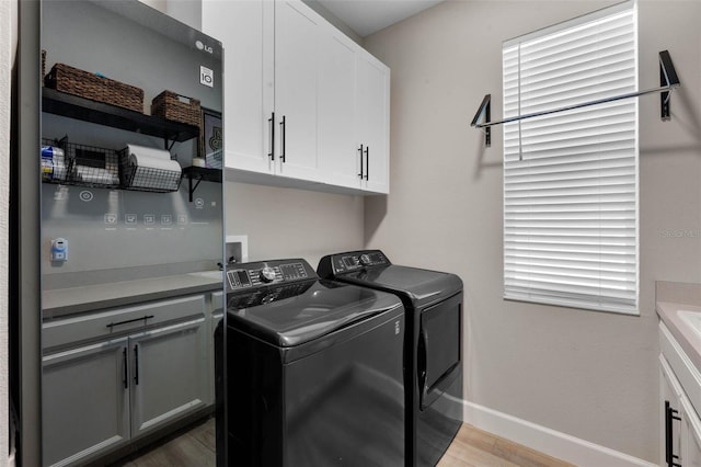 3332 Lone Cypress Pt, Oviedo, FL 32765 - laundry area with washer and dryer, cabinet space, baseboards, and light wood-style floors