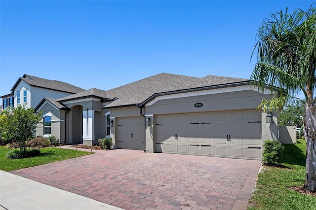 3332 Lone Cypress Pt, Oviedo, FL 32765 - view of front of home with decorative driveway, stucco siding, a garage, a front lawn, and a shingled roof