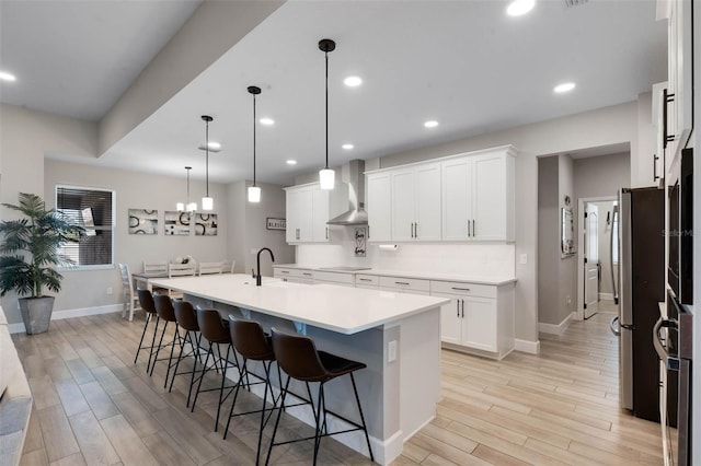 3332 Lone Cypress Pt, Oviedo, FL 32765 - kitchen featuring wall chimney exhaust hood, freestanding refrigerator, baseboards, light wood finished floors, and recessed lighting