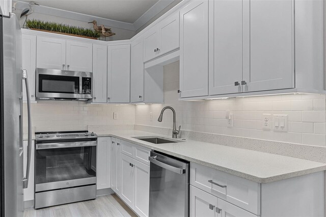 3078 Isles Way, New Smyrna Beach, FL 32168 - kitchen featuring appliances with stainless steel finishes, a sink, white cabinets, and backsplash