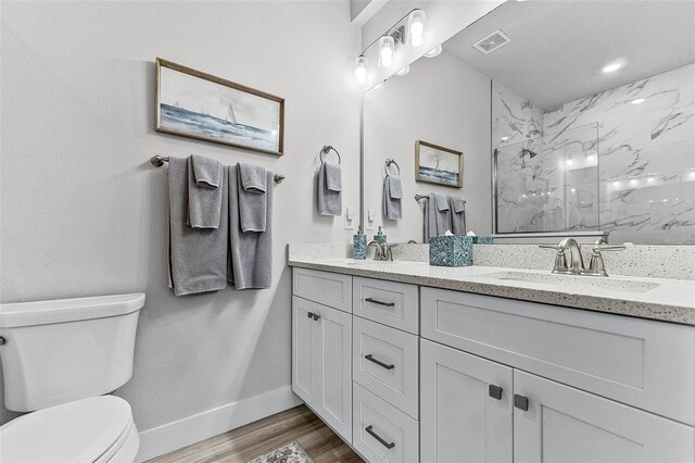3078 Isles Way, New Smyrna Beach, FL 32168 - full bathroom featuring toilet, double vanity, a marble finish shower, baseboards, and wood finished floors