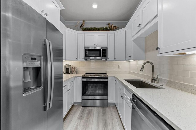 3078 Isles Way, New Smyrna Beach, FL 32168 - kitchen with stainless steel appliances, a sink, white cabinetry, light stone counters, and tasteful backsplash