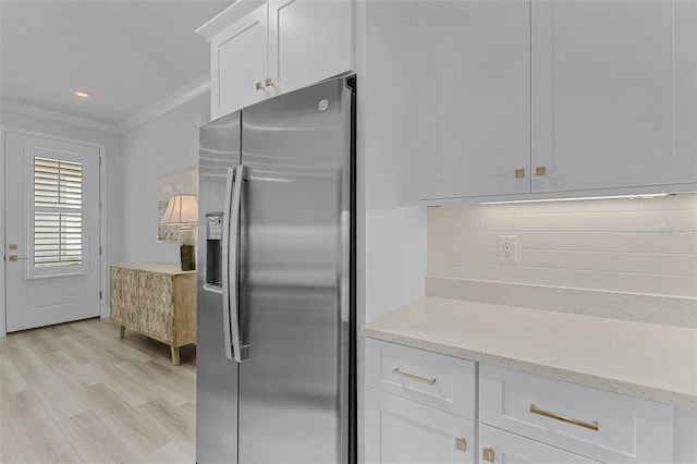 3078 Isles Way, New Smyrna Beach, FL 32168 - kitchen featuring stainless steel fridge, white cabinets, ornamental molding, decorative backsplash, and light stone counters