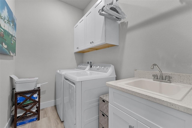 3078 Isles Way, New Smyrna Beach, FL 32168 - laundry room featuring washing machine and clothes dryer, cabinet space, light wood-type flooring, and baseboards