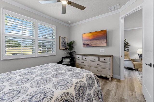 3078 Isles Way, New Smyrna Beach, FL 32168 - bedroom featuring light wood-style flooring, a textured ceiling, ceiling fan, and ornamental molding
