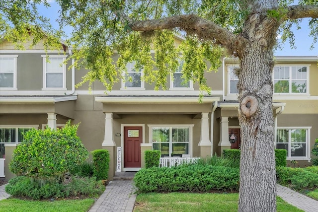 townhome / multi-family property with stucco siding and a porch