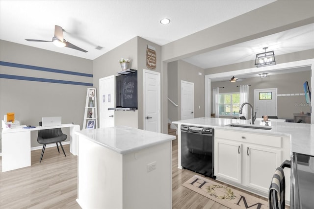 kitchen featuring white cabinets, ceiling fan, a sink, black dishwasher, and light wood-type flooring