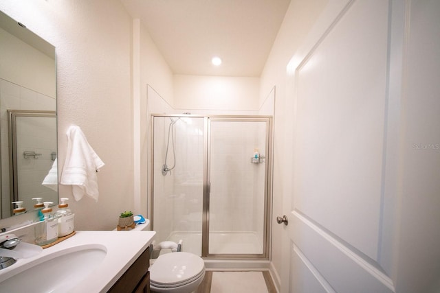 full bath with vanity, a stall shower, and toilet