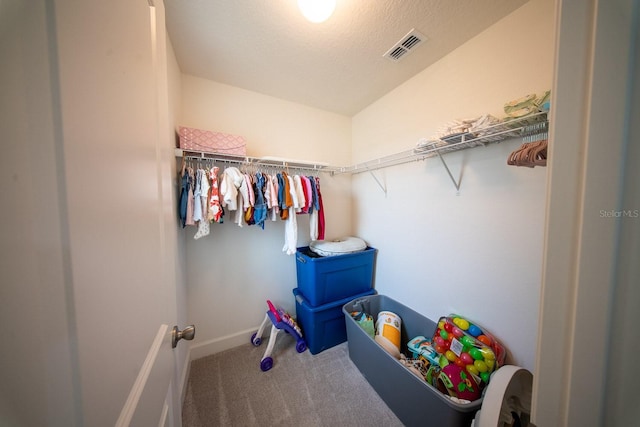 walk in closet featuring visible vents and carpet