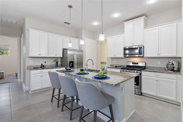 2423 Datura Loop, Saint Cloud, FL 34772 - kitchen with appliances with stainless steel finishes, a sink, a breakfast bar, white cabinetry, and recessed lighting