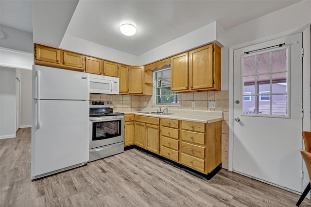 kitchen with backsplash, light wood-type flooring, a sink, light countertops, and white appliances