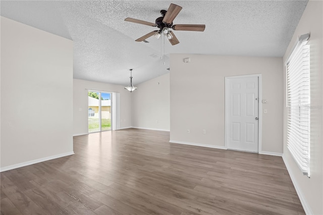 15 Sawfish Ln, Kissimmee, FL 34759 - unfurnished living room with a ceiling fan, a textured ceiling, vaulted ceiling, and wood finished floors