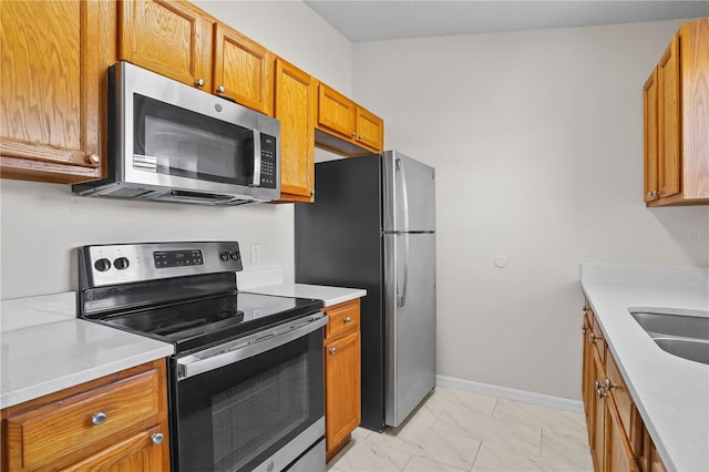 15 Sawfish Ln, Kissimmee, FL 34759 - kitchen with light countertops, stainless steel appliances, brown cabinetry, and marble finish floor