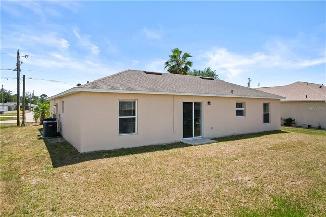 15 Sawfish Ln, Kissimmee, FL 34759 - rear view of property with a shingled roof, stucco siding, a yard, and central AC