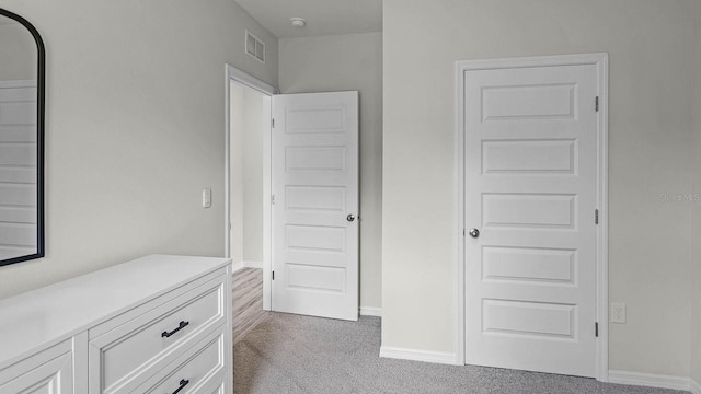 unfurnished bedroom with visible vents, carpet floors, and baseboards