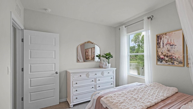 bedroom with visible vents, light colored carpet, and baseboards