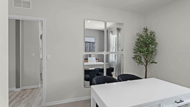 home office with baseboards, visible vents, and light wood-type flooring