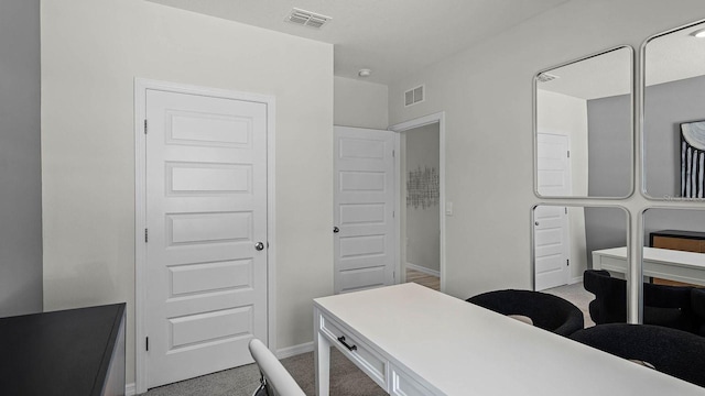 carpeted home office with visible vents and baseboards