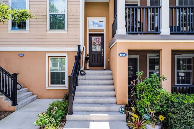 doorway to property with stucco siding and a balcony