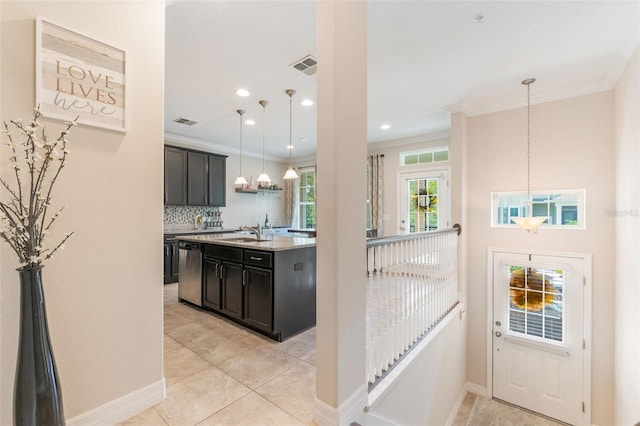 kitchen featuring decorative backsplash, crown molding, hanging light fixtures, dishwasher, and a sink