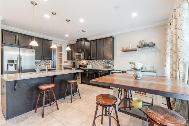kitchen featuring dark brown cabinetry, backsplash, visible vents, crown molding, and stainless steel appliances
