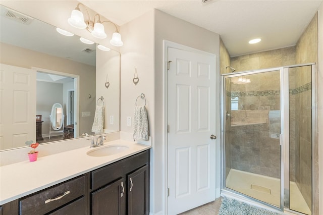 full bathroom featuring vanity, a shower stall, and visible vents