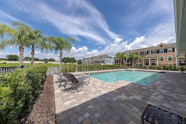 community pool featuring fence and a patio