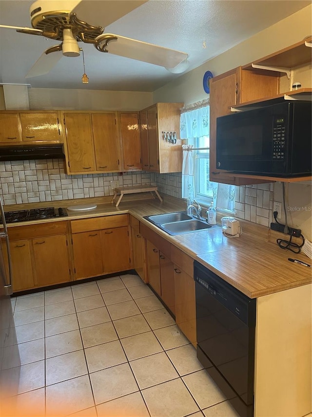 kitchen featuring a sink, tasteful backsplash, black appliances, and under cabinet range hood