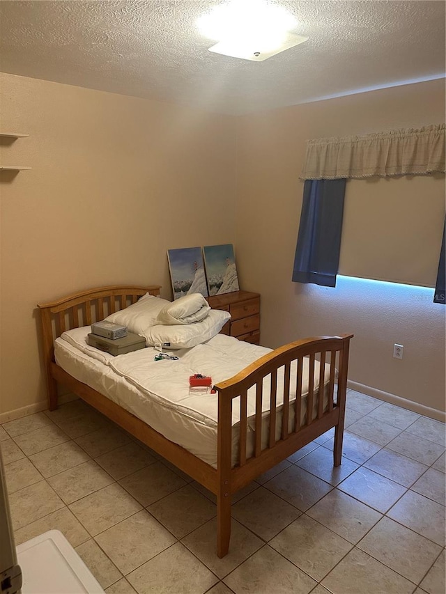 bedroom featuring baseboards and light tile patterned floors