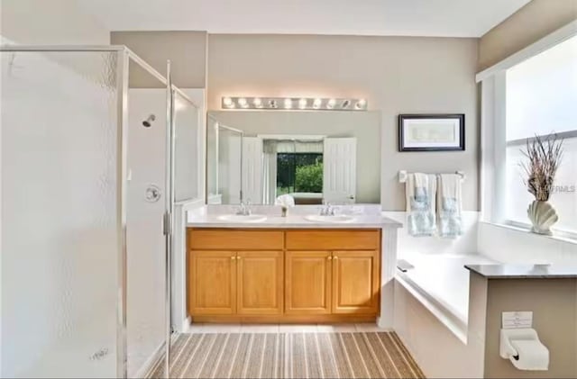 bathroom with a sink, a garden tub, double vanity, and a shower stall