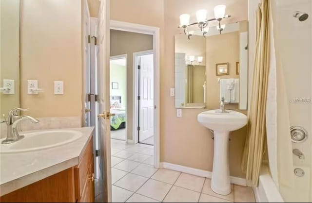 bathroom featuring shower / bath combo, a sink, tile patterned floors, and baseboards