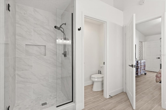 342 Hanging Moss Cir, Lake Mary, FL 32746 - bathroom with toilet, wood tiled floor, a shower stall, and baseboards