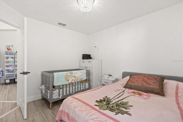 342 Hanging Moss Cir, Lake Mary, FL 32746 - bedroom with a textured ceiling, visible vents, wood finish floors, and baseboards