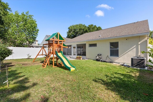 342 Hanging Moss Cir, Lake Mary, FL 32746 - back of house with stucco siding, a yard, fence private yard, central AC, and a playground