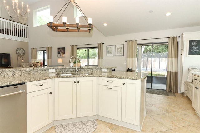 kitchen featuring stainless steel dishwasher, a sink, a notable chandelier, and a wealth of natural light