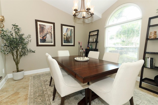 dining area featuring baseboards, vaulted ceiling, and a chandelier