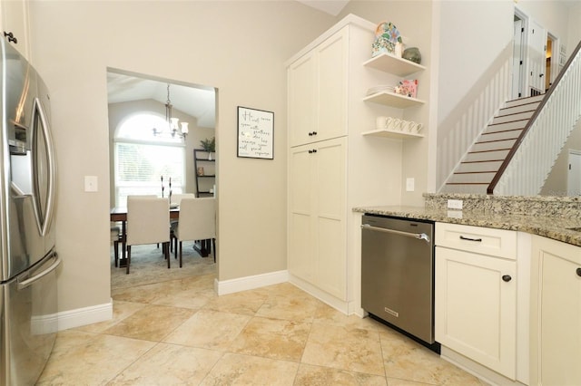 kitchen with light stone countertops, appliances with stainless steel finishes, open shelves, a chandelier, and lofted ceiling